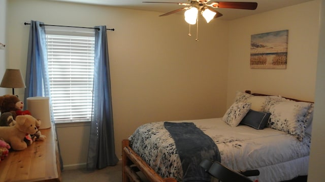 carpeted bedroom with ceiling fan and baseboards