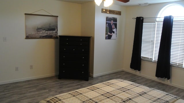 unfurnished bedroom with ceiling fan, wood finished floors, visible vents, and baseboards