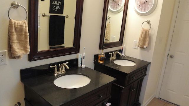 bathroom with tile patterned flooring, two vanities, and a sink