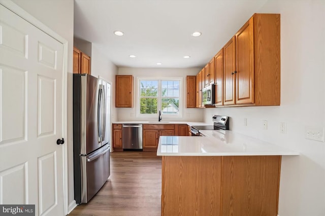 1118 Virginia Ave, Culpeper, VA 22701 - kitchen with stainless steel appliances, a peninsula, brown cabinetry, and recessed lighting