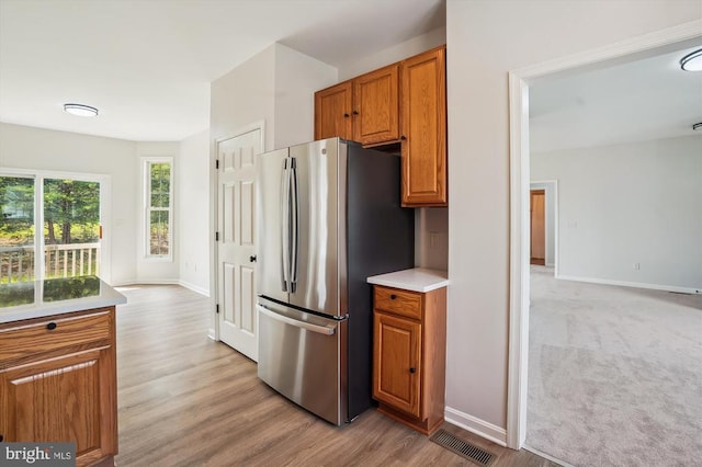 1118 Virginia Ave, Culpeper, VA 22701 - kitchen featuring freestanding refrigerator, brown cabinets, light wood-style flooring, and light countertops