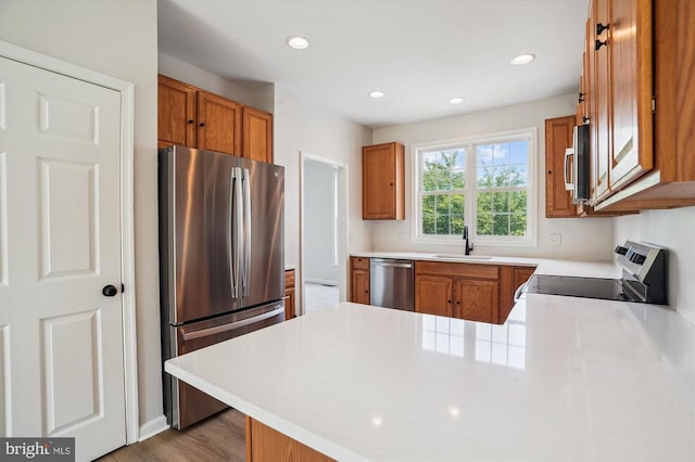 1118 Virginia Ave, Culpeper, VA 22701 - kitchen featuring appliances with stainless steel finishes, a peninsula, brown cabinetry, light countertops, and recessed lighting