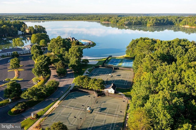 view of property location featuring a nearby body of water and a forest