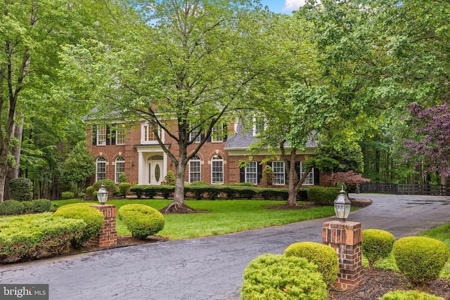 colonial house with a front yard and brick siding