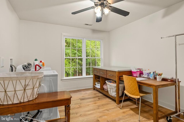 home office with light wood-style floors, healthy amount of natural light, ceiling fan, and washer and dryer