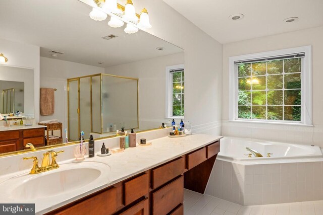 bathroom featuring a shower stall, a tub with jets, vanity, tile patterned flooring, and a chandelier