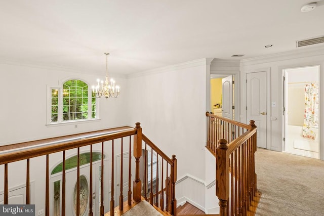 stairway featuring a chandelier, ornamental molding, and carpet flooring
