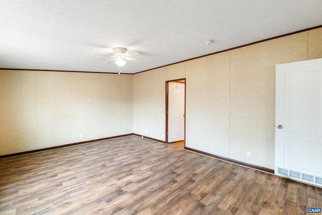 empty room with wood finished floors, crown molding, a textured ceiling, visible vents, and ceiling fan