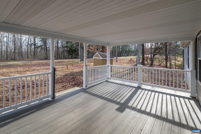 wooden deck with an outbuilding and a storage unit