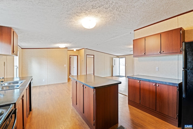 kitchen featuring freestanding refrigerator, dark countertops, light wood-type flooring, and electric range