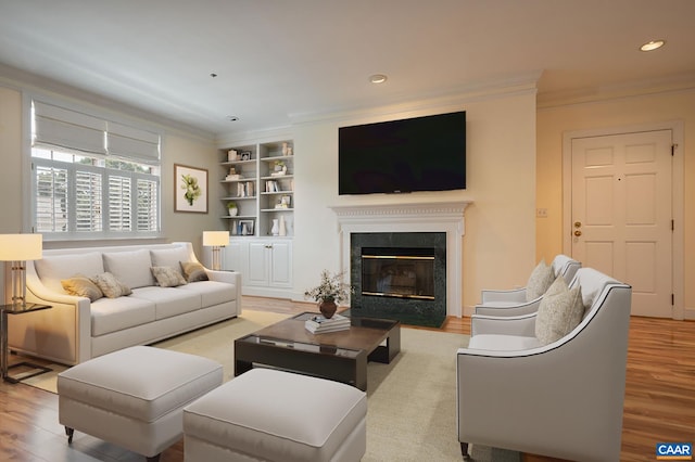 217 E Jefferson St, Charlottesville, VA 22902 - living room with crown molding, light wood-style floors, built in features, recessed lighting, and a premium fireplace