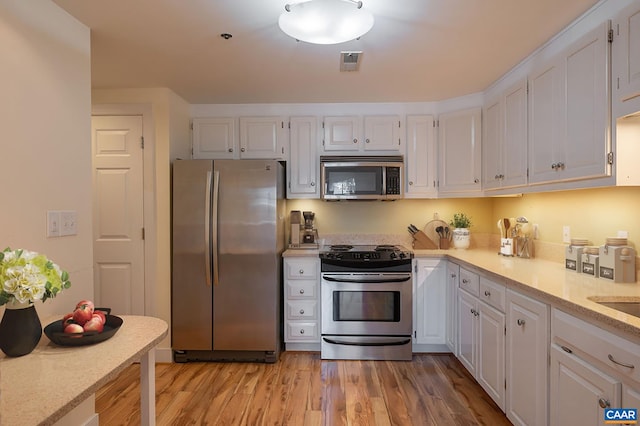 217 E Jefferson St, Charlottesville, VA 22902 - kitchen featuring appliances with stainless steel finishes, white cabinetry, and light wood-style floors