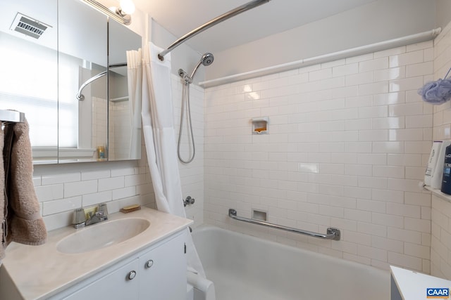 bathroom with vanity, shower / bath combo, visible vents, and tasteful backsplash