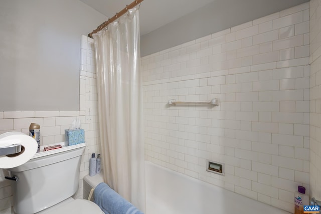 full bath with tile walls, toilet, and shower / tub combo