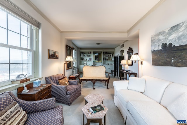 carpeted living area with ornamental molding, a wealth of natural light, and visible vents