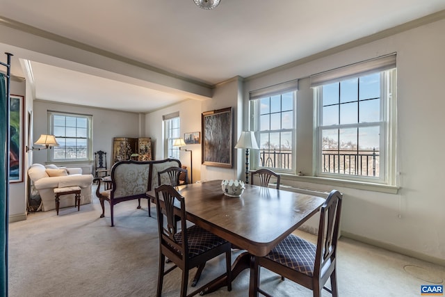carpeted dining area featuring ornamental molding and baseboards