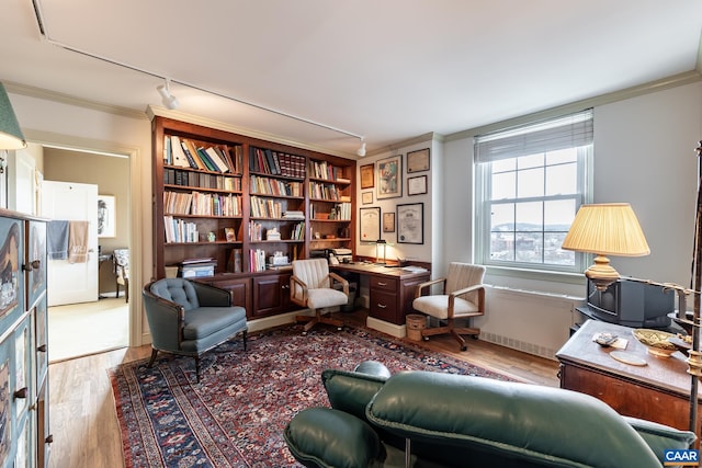 living area with ornamental molding, track lighting, and wood finished floors