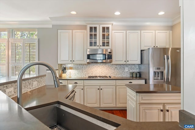 1664 Wickham Way, Charlottesville, VA 22901 - kitchen featuring appliances with stainless steel finishes, ornamental molding, tasteful backsplash, dark countertops, and glass insert cabinets