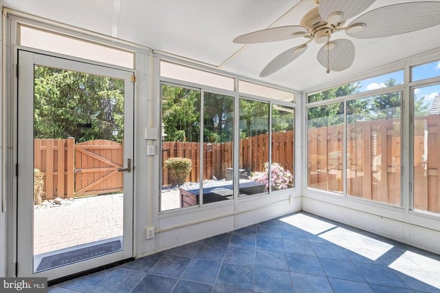 unfurnished sunroom with ceiling fan