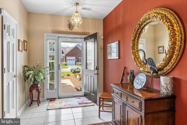 foyer entrance featuring light tile patterned flooring and a chandelier