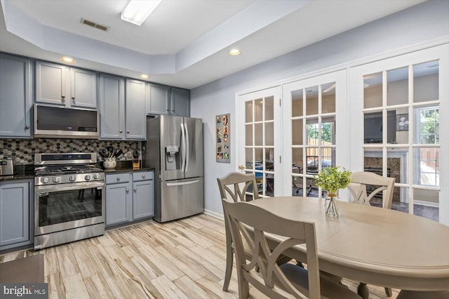 kitchen featuring stainless steel appliances, gray cabinets, french doors, dark countertops, and recessed lighting