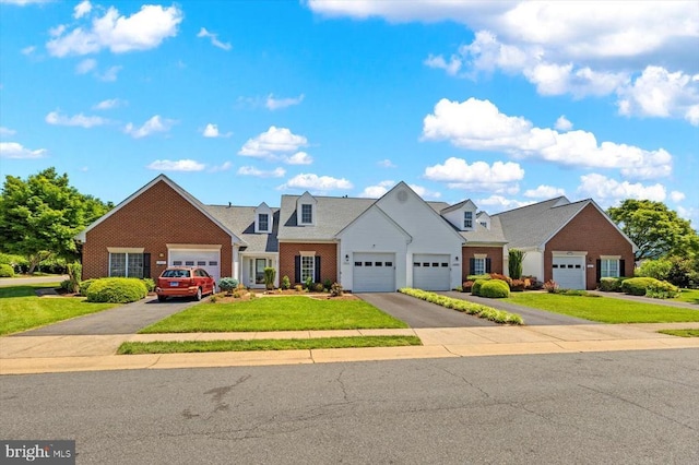 view of front of home with a front yard, asphalt driveway, brick siding, and a garage