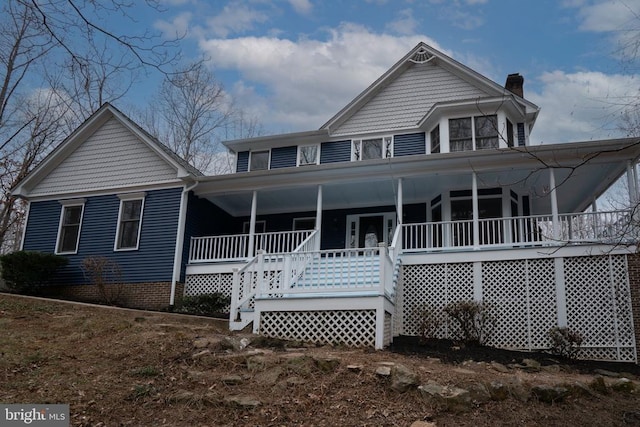 rear view of house featuring a chimney, a porch, and stairway