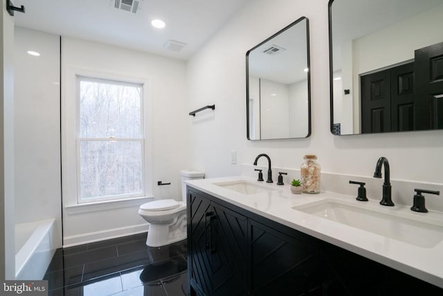 full bath featuring toilet, tile patterned floors, healthy amount of natural light, and double vanity