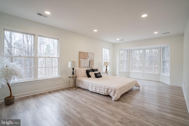bedroom with baseboards, wood finished floors, and recessed lighting