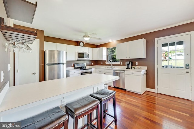 15605 Cedar Tree Ct, Mineral, VA 23117 - kitchen featuring appliances with stainless steel finishes, a peninsula, light wood-style floors, a breakfast bar, and light countertops