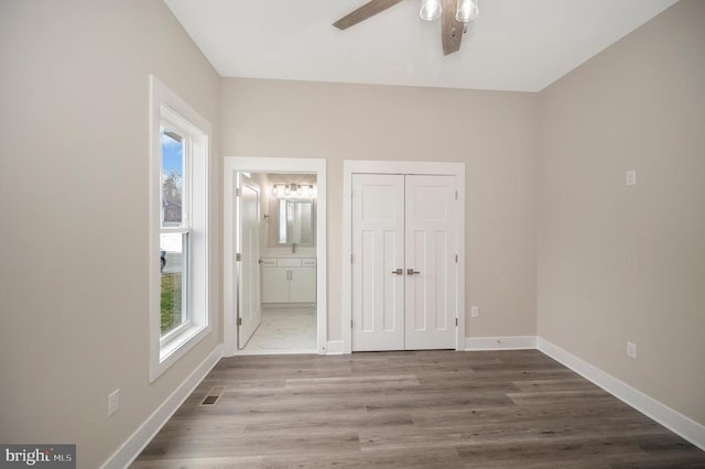573 Sunset Loop, Mineral, VA 23117 - unfurnished bedroom with wood finished floors, a closet, connected bathroom, and a ceiling fan