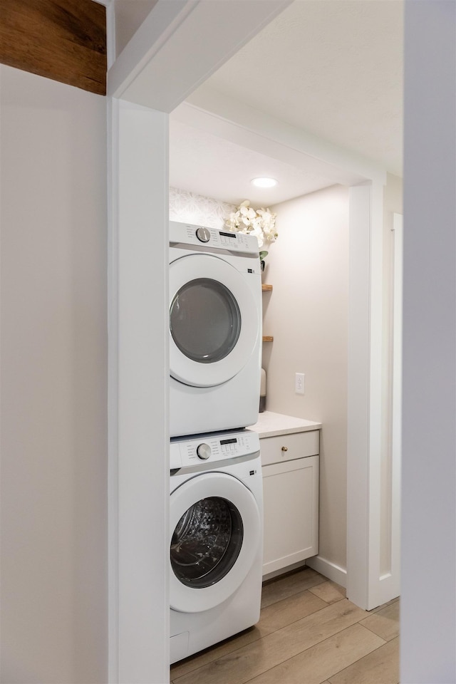 519 Arpia St, Lexington, VA 24450 - laundry area featuring stacked washer / drying machine, light wood-style floors, and cabinet space