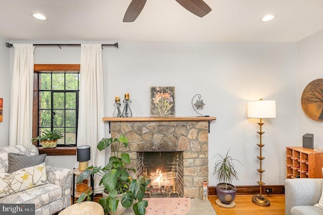 living area with wood finished floors, recessed lighting, baseboards, a ceiling fan, and a fireplace