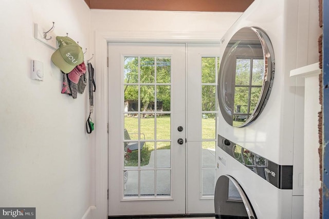 doorway with stacked washing machine and dryer, plenty of natural light, and french doors