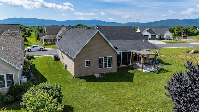 193 Locust Grove Ln, Stuarts Draft, VA 24477 - back of property featuring a mountain view, a patio area, a lawn, and roof with shingles