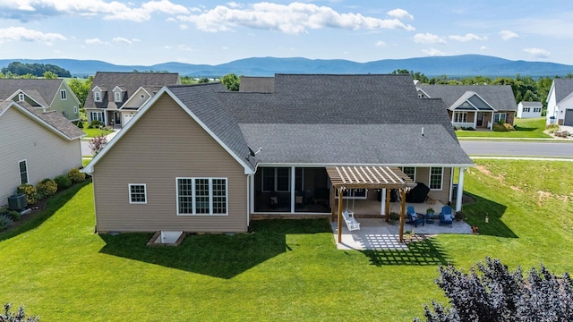 193 Locust Grove Ln, Stuarts Draft, VA 24477 - back of property featuring a mountain view, a shingled roof, a lawn, a patio area, and a residential view