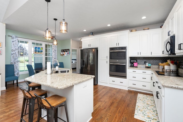 193 Locust Grove Ln, Stuarts Draft, VA 24477 - kitchen featuring black appliances, wood finished floors, white cabinetry, a kitchen breakfast bar, and decorative backsplash
