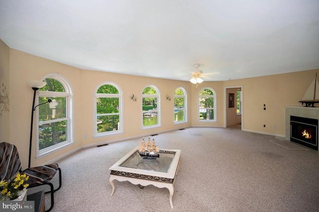 unfurnished living room with carpet, healthy amount of natural light, and a tile fireplace