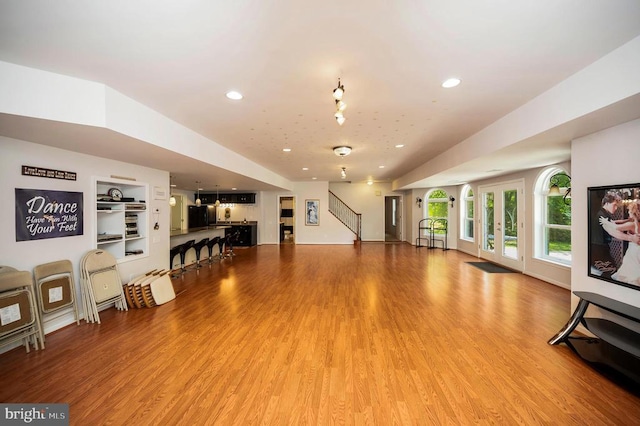 living area with recessed lighting, light wood-style floors, and stairs