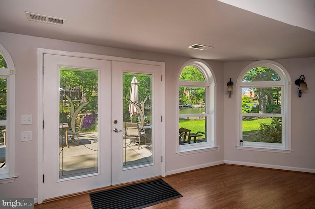 entryway with french doors, wood finished floors, a water view, and baseboards