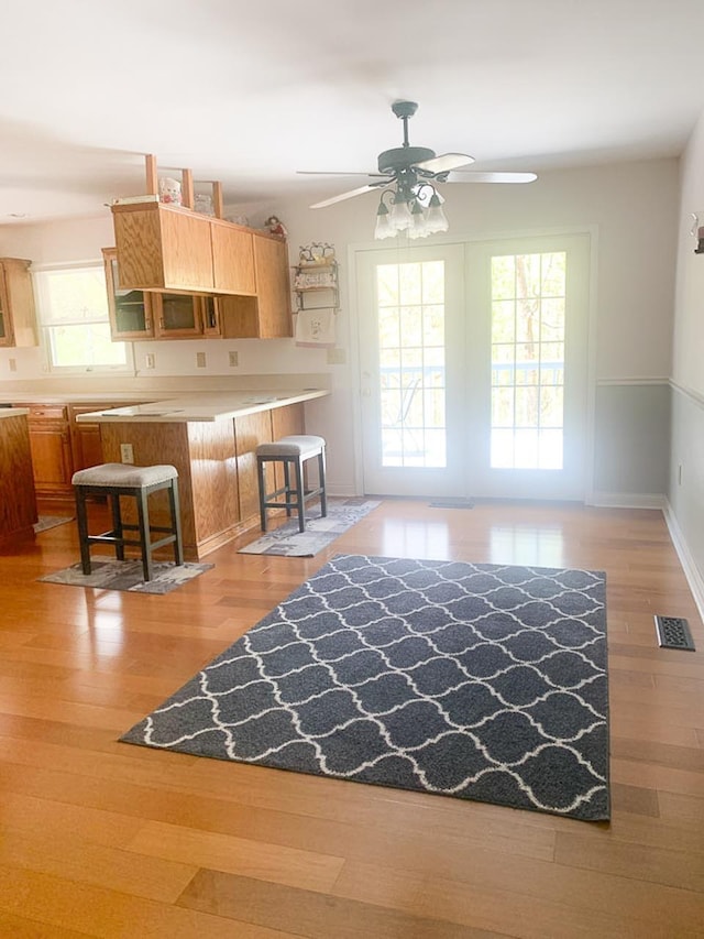 209 Raintree Rd, Verona, VA 24482 - kitchen with healthy amount of natural light, ceiling fan, a kitchen bar, and light wood-type flooring