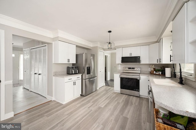 11603 Enchanted Woods Way, Fredericksburg, VA 22407 - kitchen with appliances with stainless steel finishes, light wood-style flooring, a sink, white cabinetry, and crown molding