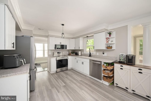 11603 Enchanted Woods Way, Fredericksburg, VA 22407 - kitchen with appliances with stainless steel finishes, light wood-style floors, white cabinetry, ornamental molding, and decorative light fixtures