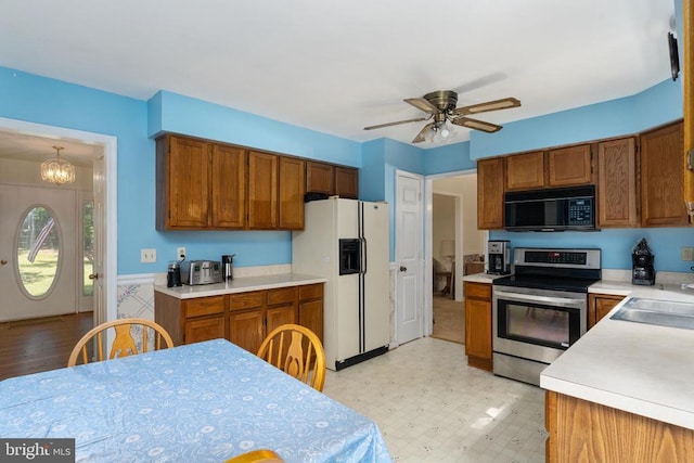 13403 Motts Run Rd, Fredericksburg, VA 22407 - kitchen with white refrigerator with ice dispenser, black microwave, electric range, brown cabinets, and light countertops