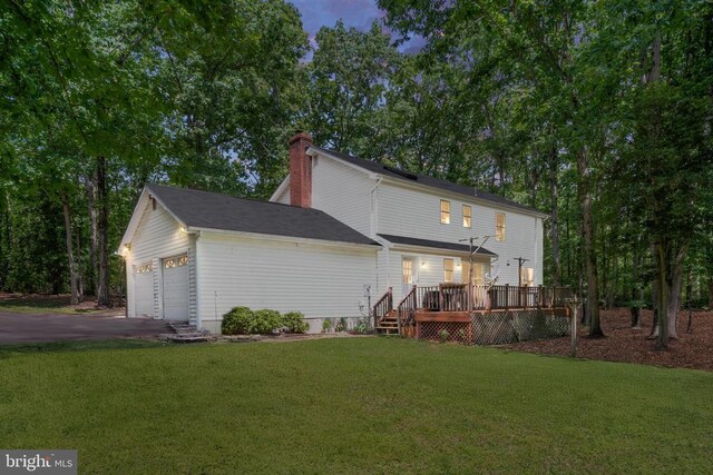 13403 Motts Run Rd, Fredericksburg, VA 22407 - back of house featuring a lawn, a garage, a chimney, a deck, and asphalt driveway