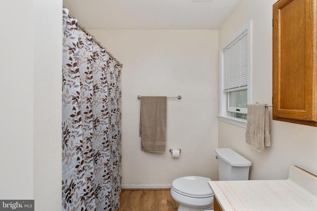 13403 Motts Run Rd, Fredericksburg, VA 22407 - bathroom with vanity, toilet, wood finished floors, a shower with shower curtain, and baseboards