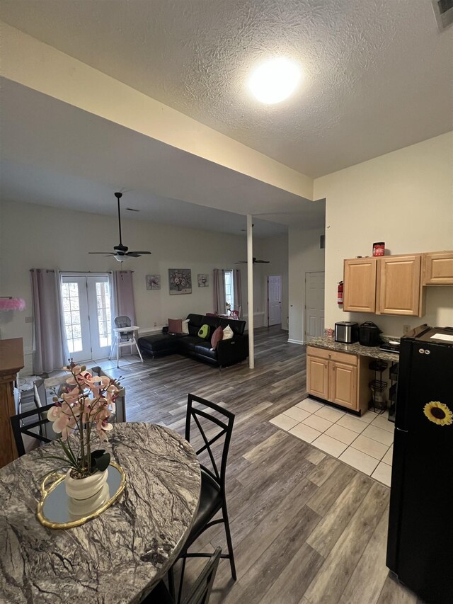 dining space with french doors, light wood-type flooring, visible vents, a textured ceiling, and ceiling fan