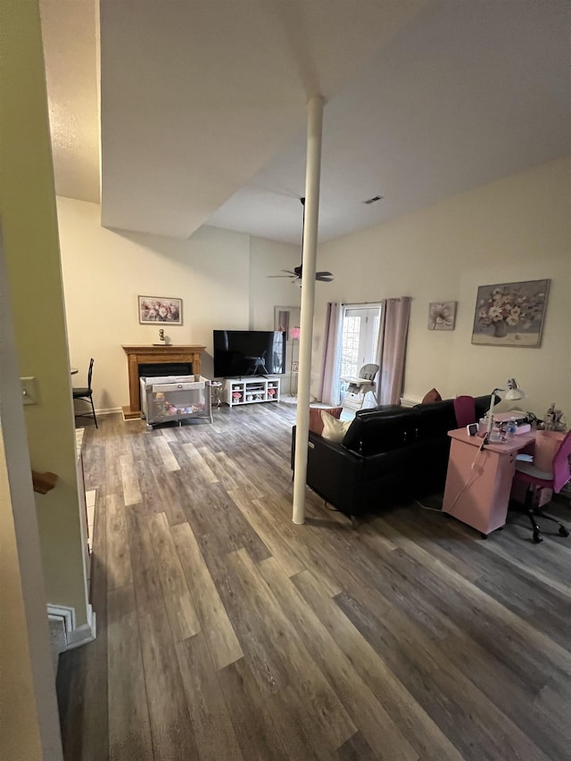 living room featuring ceiling fan and dark wood-type flooring