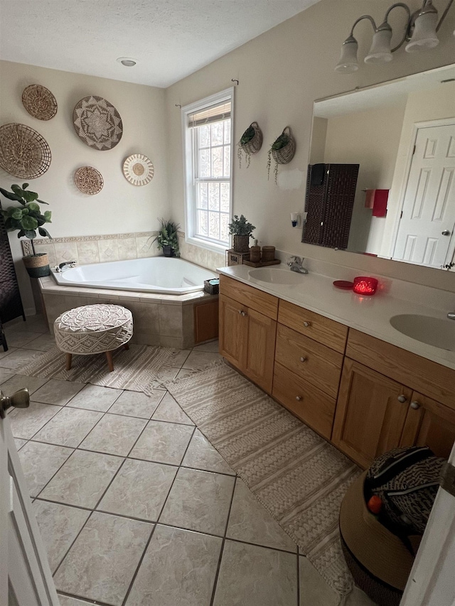 full bathroom with double vanity, a bath, tile patterned flooring, and a sink