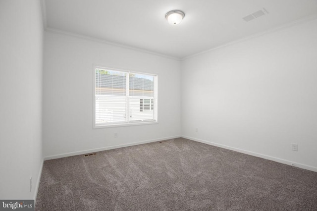 carpeted spare room featuring crown molding and baseboards